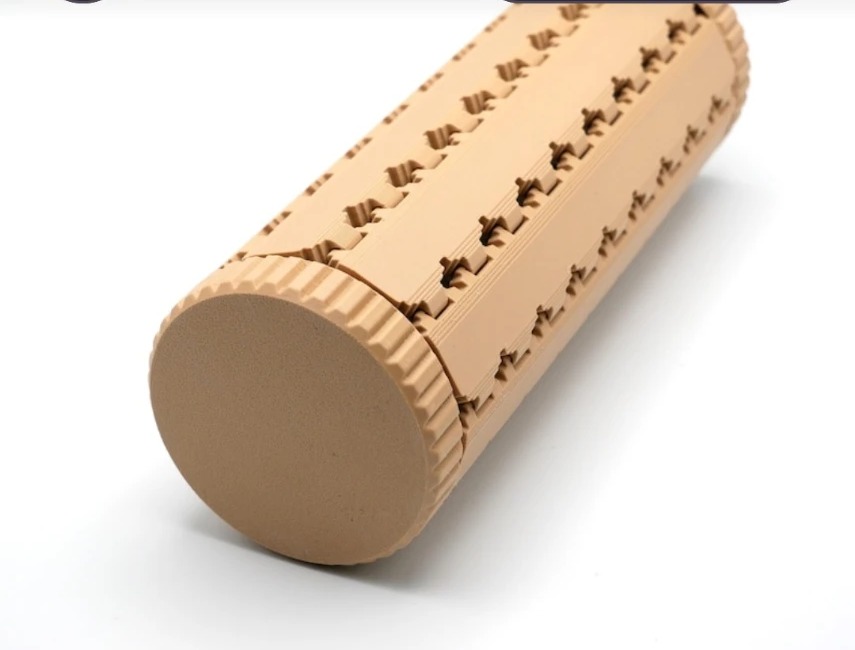 The tile grid rolled into a closed cylinder with ridged screw caps at both ends, lying on its side